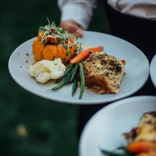 a person holding plates of food