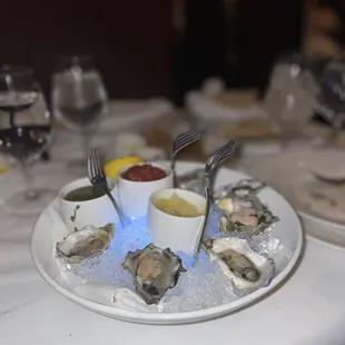 a plate of oysters with ketchup and condiments