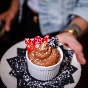 a person holding a plate with a dessert