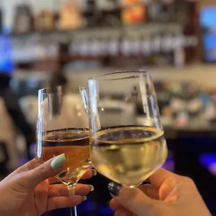 two people clinking glasses of wine