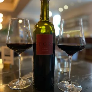 two glasses of wine and a bottle of wine