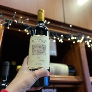 a hand holding a bottle of wine