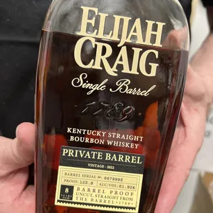 a person holding a bottle of elijah craig