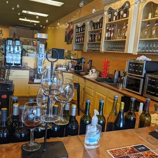a bar with wine glasses and bottles