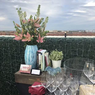 a table with wine glasses and a vase of flowers