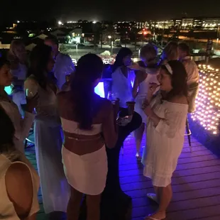 a group of people standing on a rooftop at night