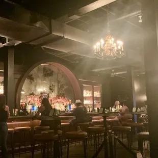 a dimly lit bar with a chandelier