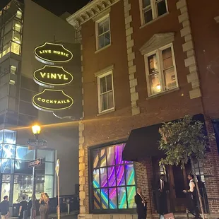 a storefront at night with people standing outside