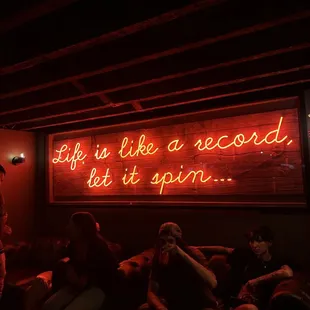 a neon sign that reads life is like a record let it spin