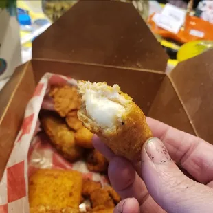 a hand holding a half eaten doughnut