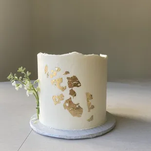 a white cake with gold foiling