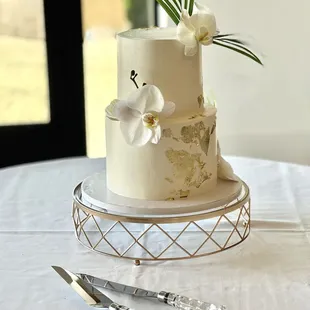 ivory buttercream wedding cake with white orchids and palm leaves