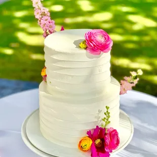 Contemporary wedding cake adorned with hot pink flowers