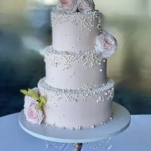 pink wedding cake embellished with pearls and pink roses