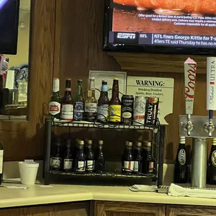 a pizza on a counter with a television in the background