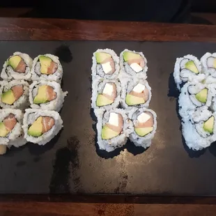Assortment of sushi , left salmon avocado roll, Philadelphia roll and crab avocado roll