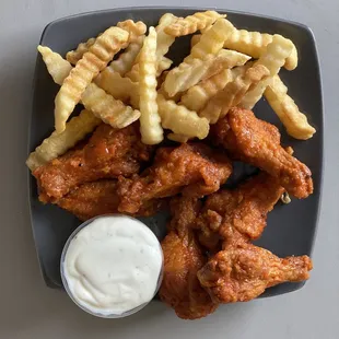 a plate of chicken wings and fries