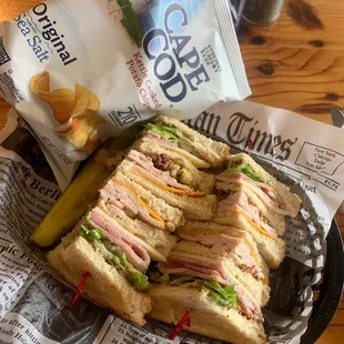 Club sandwich with kettle chips and kosher dill pickle strip.