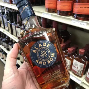 a hand holding a bottle of black label bourbon
