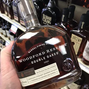 a hand holding a bottle of woodford reserve double oak