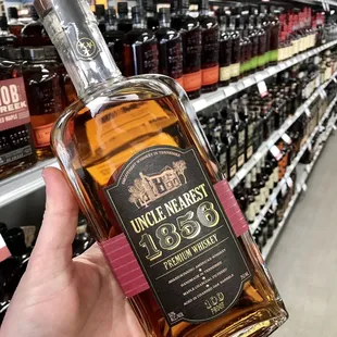 a hand holding a bottle of bourbon
