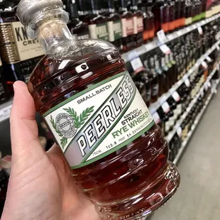 a person holding up a bottle of beer