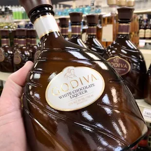 a hand holding a bottle of brandy