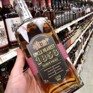 a hand holding a bottle of whiskey