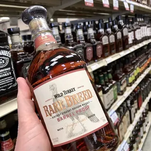 a hand holding a bottle of whiskey