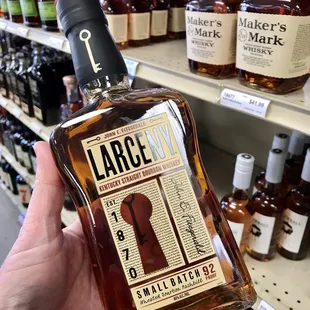 a hand holding a bottle of large city bourbon