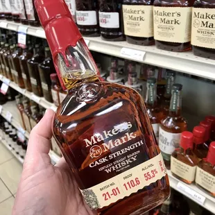 a hand holding a bottle of whiskey