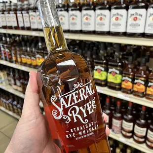 a hand holding a bottle of bourbon