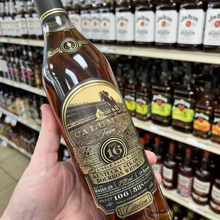 a hand holding a bottle of brandy