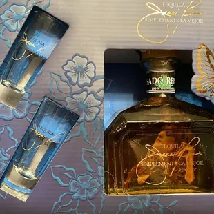 a bottle of alcohol and two shot glasses