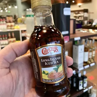 a hand holding a bottle of liquor