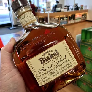 a hand holding a bottle of bluebird bourbon