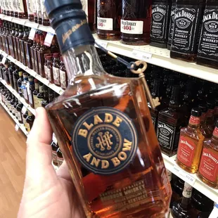 a hand holding a bottle of whiskey