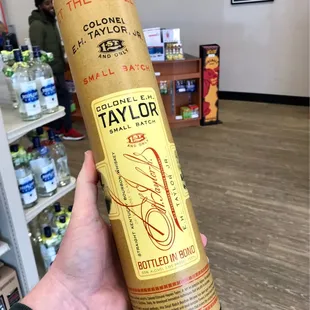 a hand holding a bottle of taylor's bourbon