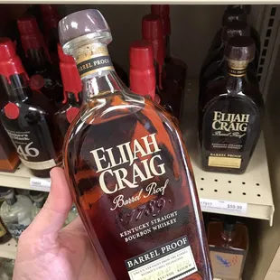 a hand holding a bottle of elijah craig bourbon