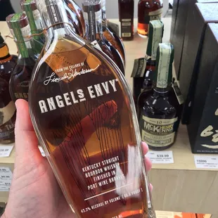 a hand holding a bottle of angel's envy