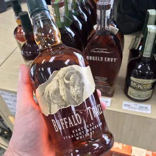 a hand holding a bottle of buffalo bay bourbon