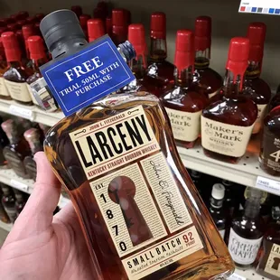 a hand holding a bottle of largeny bourbon