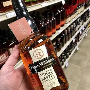 a hand holding a bottle of single barrel bourbon
