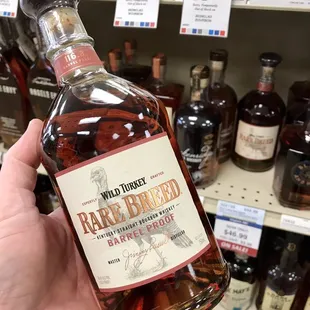 a hand holding a bottle of rare breed bourbon