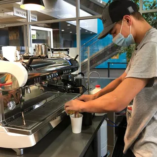 a man preparing a cup of coffee