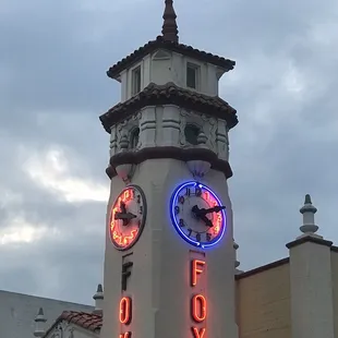 a clock tower with neon lights