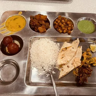 a metal tray with a variety of food items