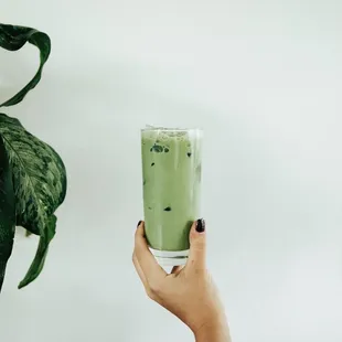  person holding a glass of green tea