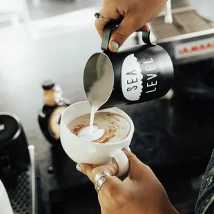  person pouring milk into a cup