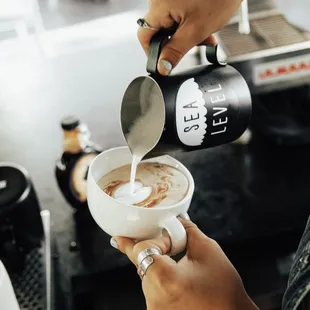  person pouring milk into a cup